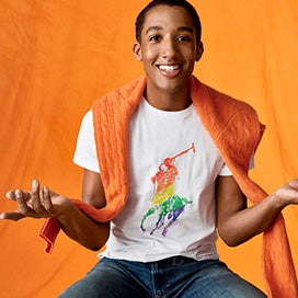 Harper Watters in rainbow Pony white tee with orange sweater over shoulders