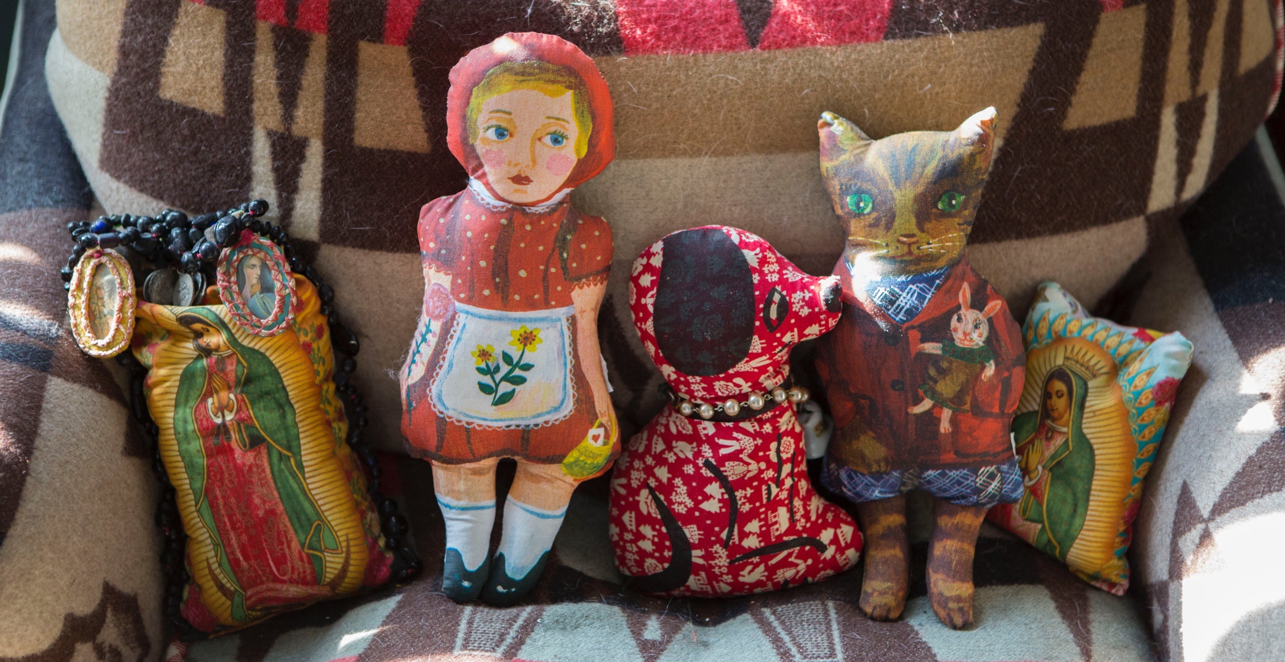 Little Red Riding Hood and friends nestled cozily on a bedroom chaise covered in a faded Ralph Lauren textile