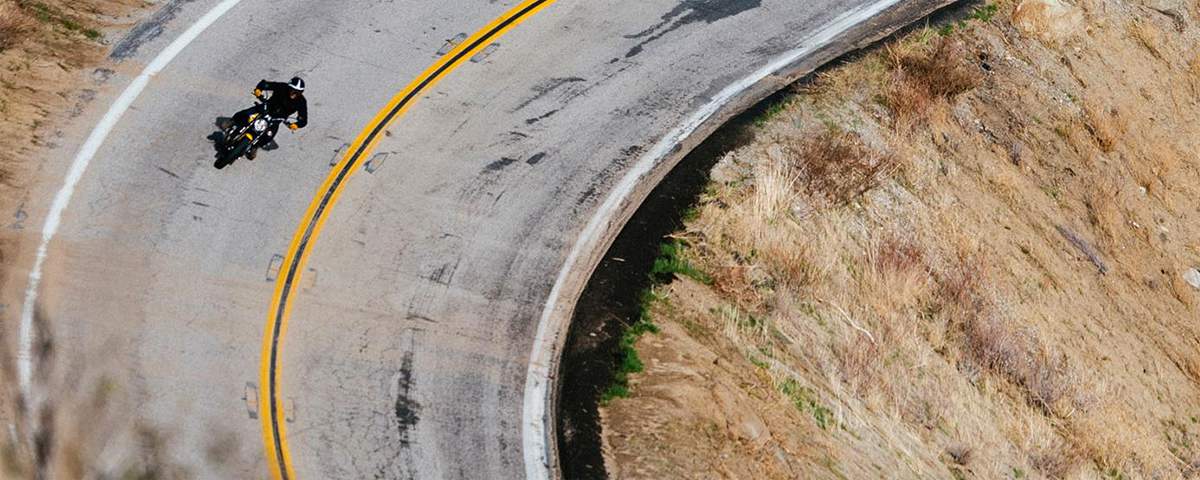 Bird's-eye view of man riding motorcycle on highway