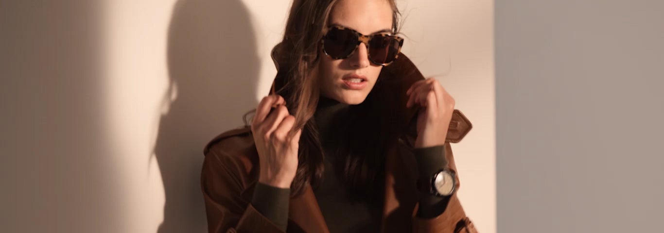 Video of woman wearing brown leather trench coat & other RL icons