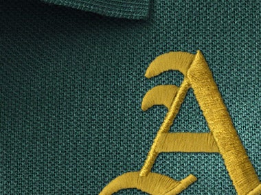 Golden embroidered gothic A on green fabric