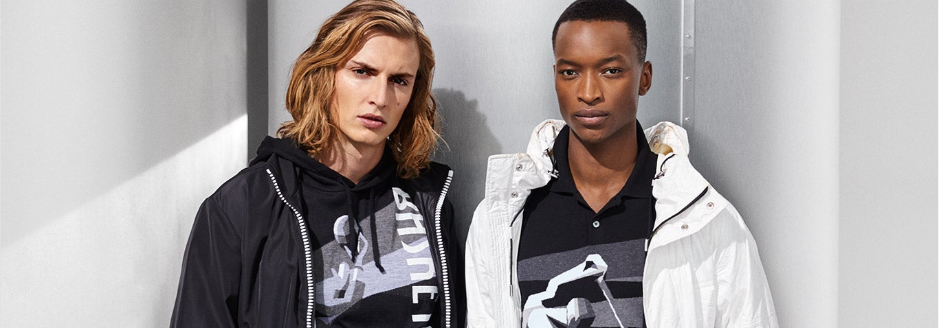 Two men in shirts with graphics inspired by vintage athletic posters