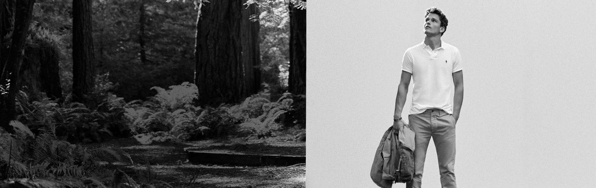 Man in woods in white Polo shirt holding denim jacket