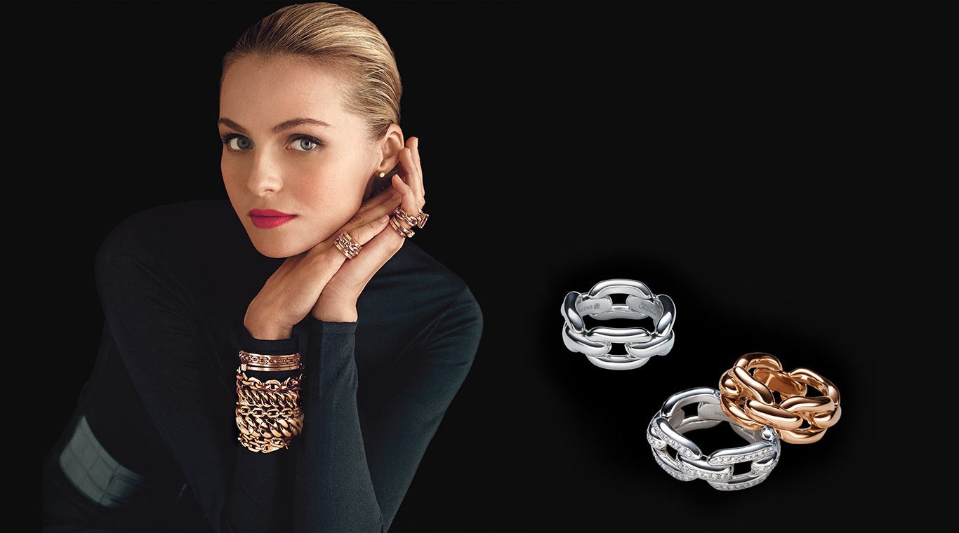 Woman in black turtleneck wearing stacked gold bracelets & rings
