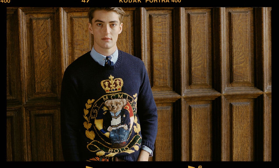 Man in navy sweater with large Polo Bear crest motif