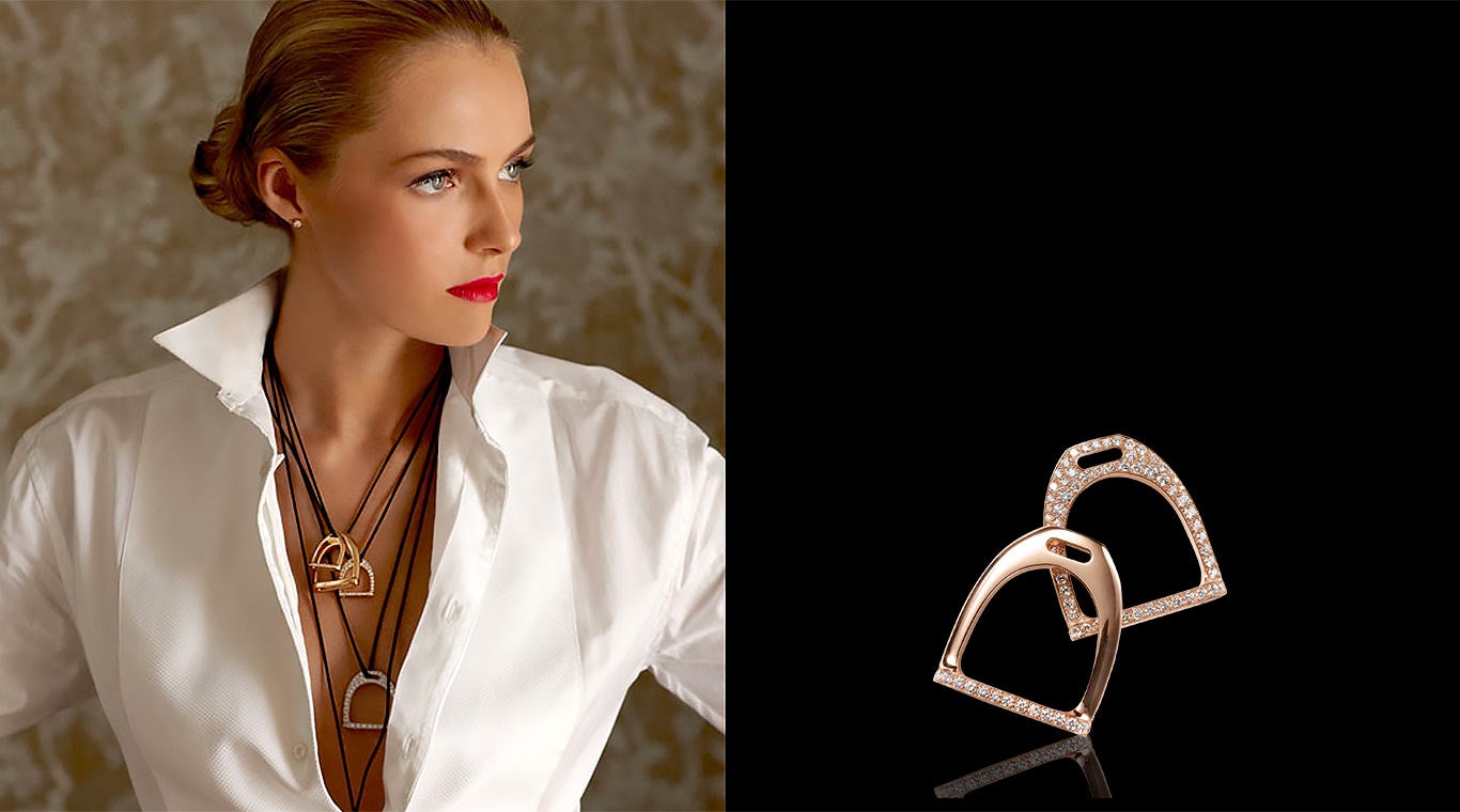 Woman wearing multiple horseshoe pendant necklaces & white blouse