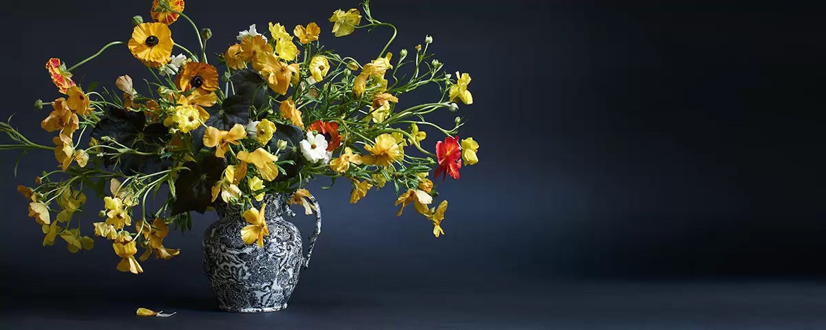 Navy pitcher used as vase for yellow wildflower arrangement