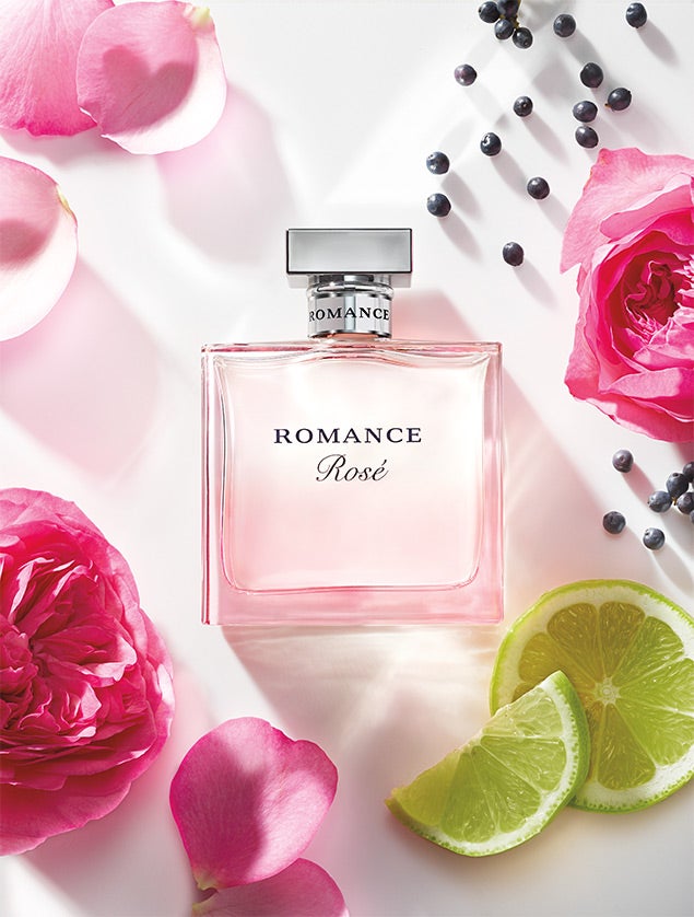 Bottle of Romance Rosé surrounded by florals, bergamot & black currant