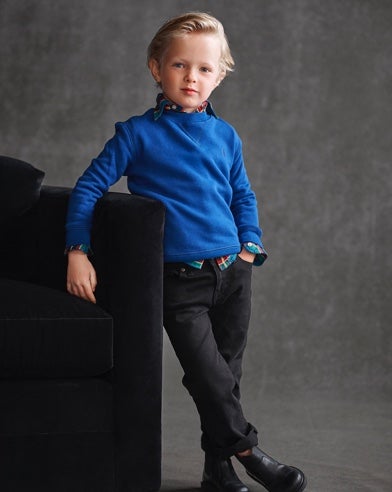 Boy wears blue sweater over plaid button-down and black pants