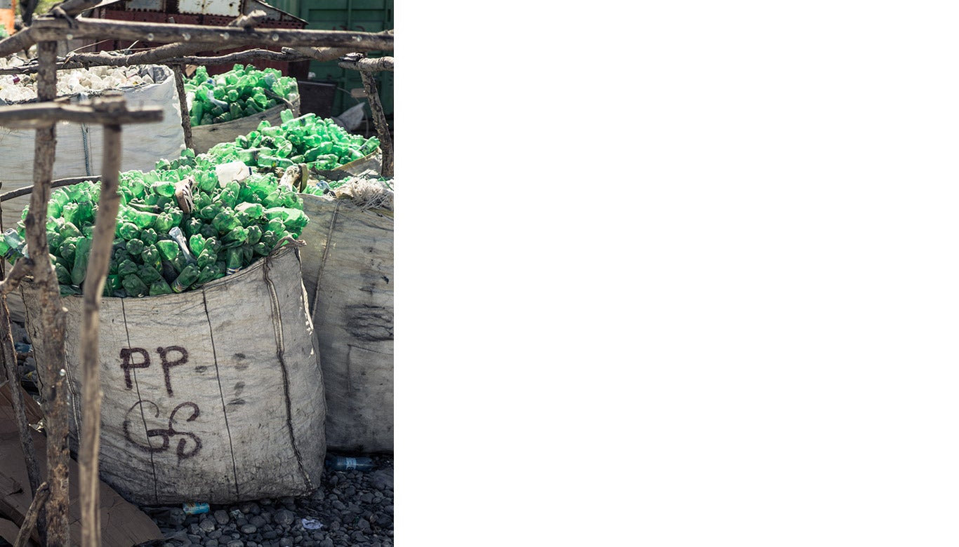 Large bags full of green plastic bottles.