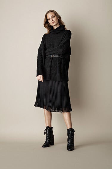Woman in black pleated skirt