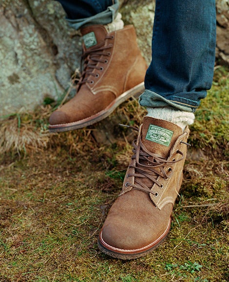 Worn brown leather low-top boots with laces