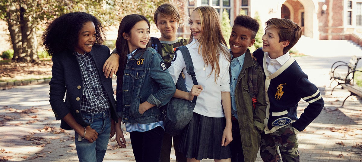 Kids stand outside wearing back-to-school outfits.