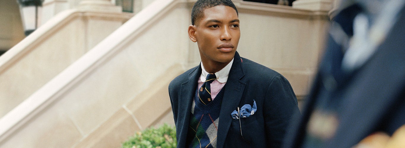 Man in navy sport coat, argyle sweater, shirt & tie