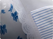 Lace-trim white pillow & sheeting with blue stripes & florals.