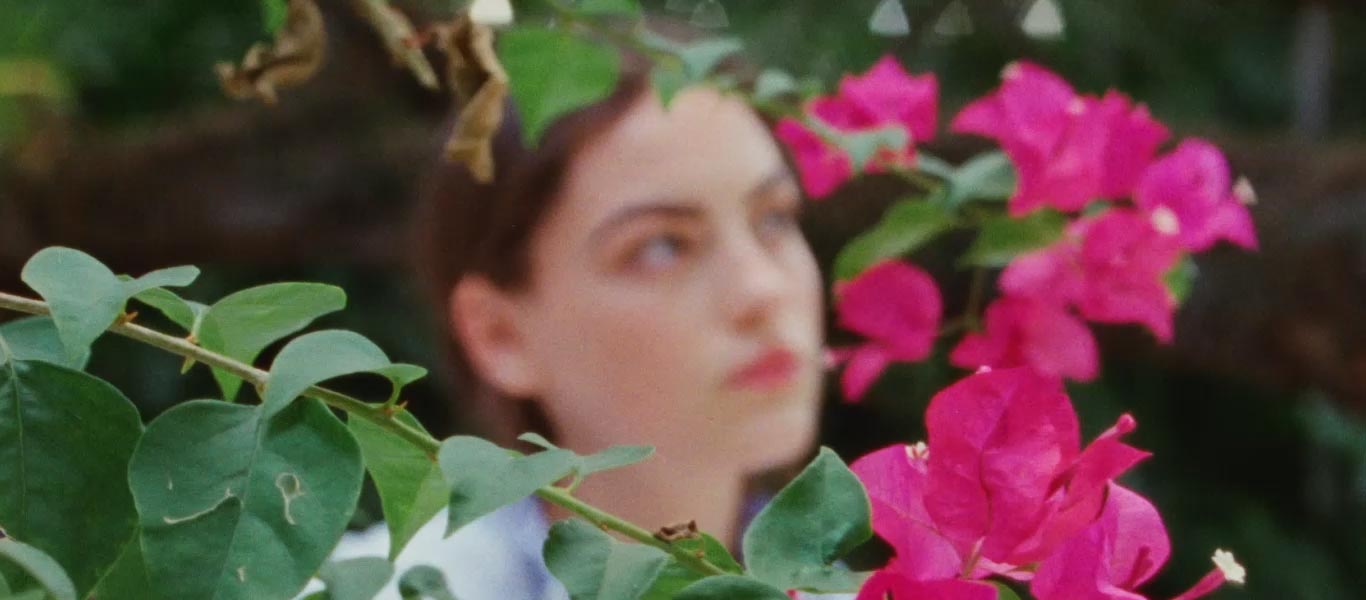 Video of woman in striped shirt and white skirt near blossoming tree
