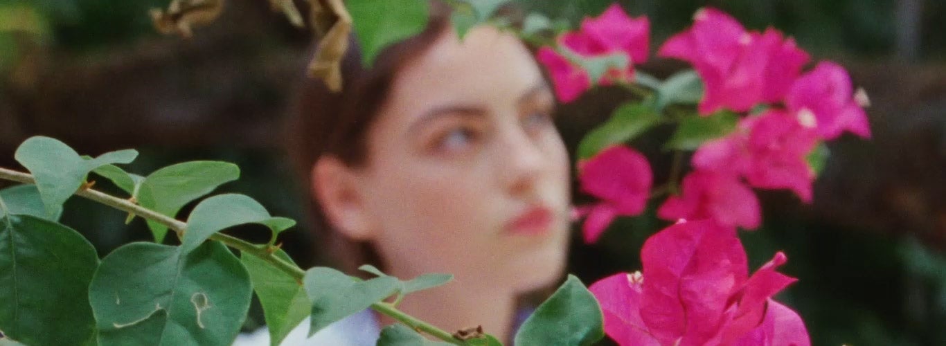 Woman in striped shirt standing near tree in full bloom