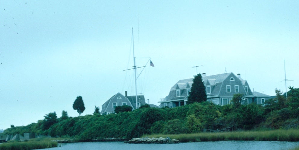 Grey paneled cottages by grassy inlet