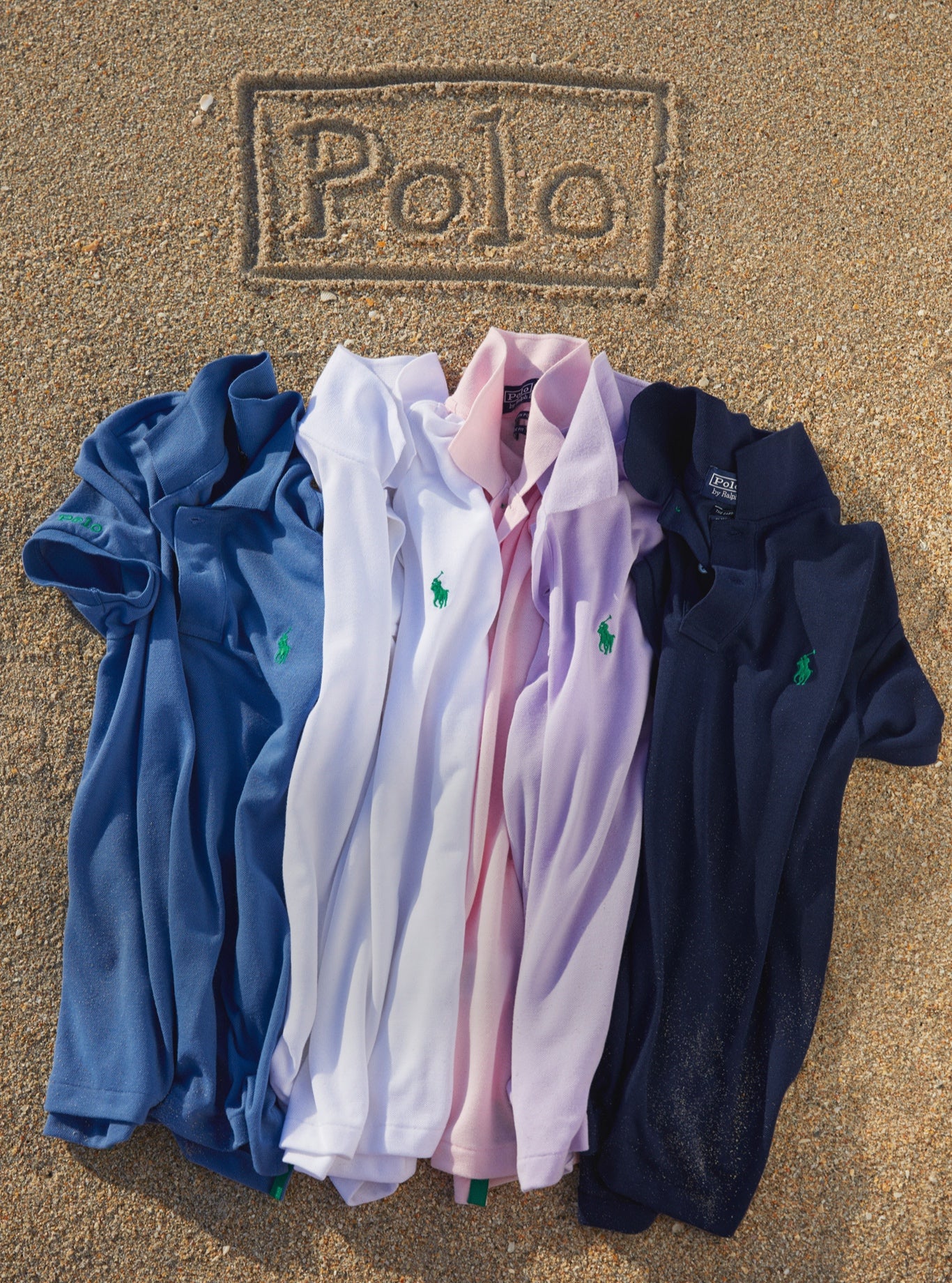 Earth Polo shirts in various colors on sandy beach.