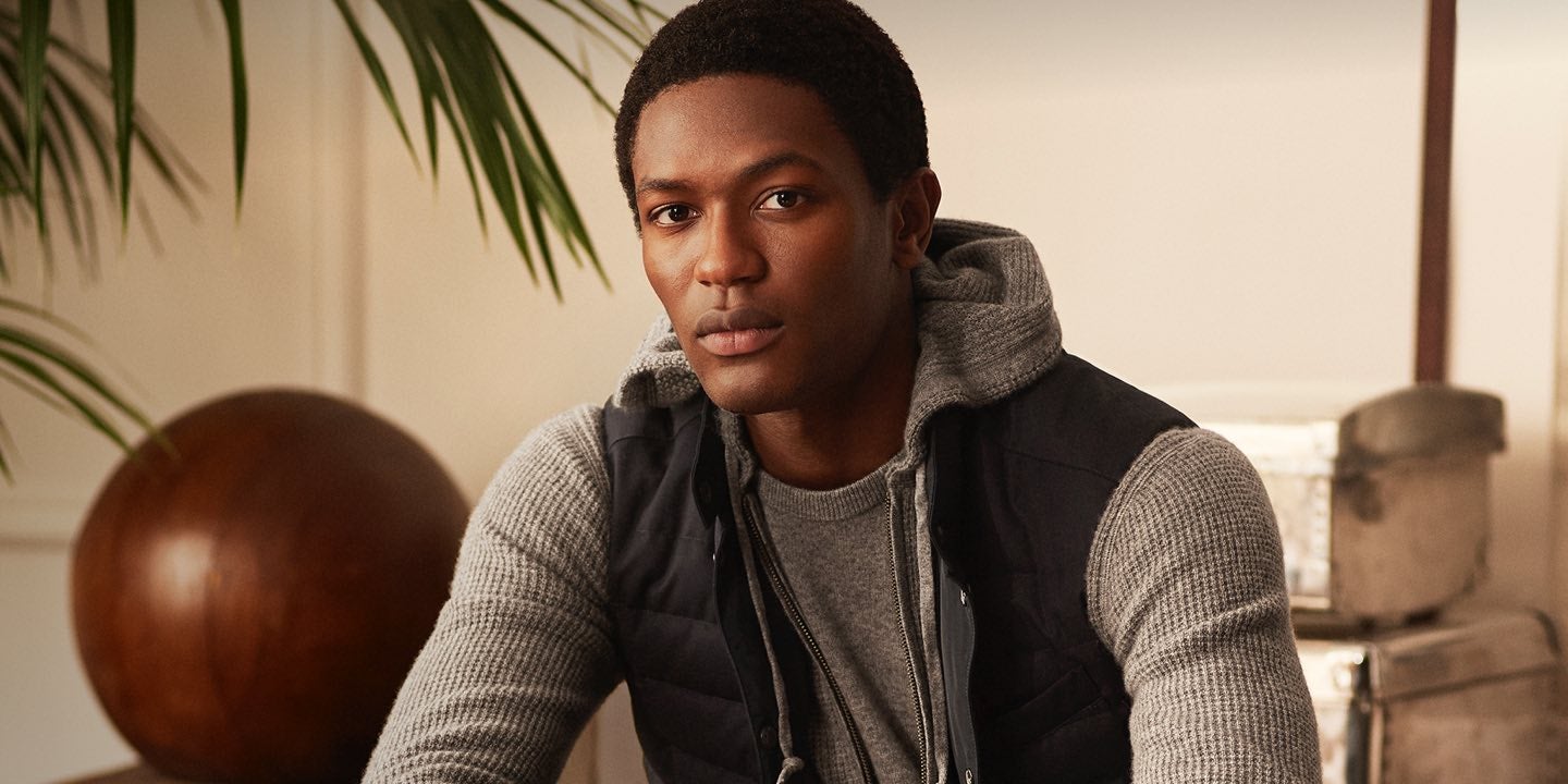 Man in tan waffle-knit full-zip hoodie & black vest