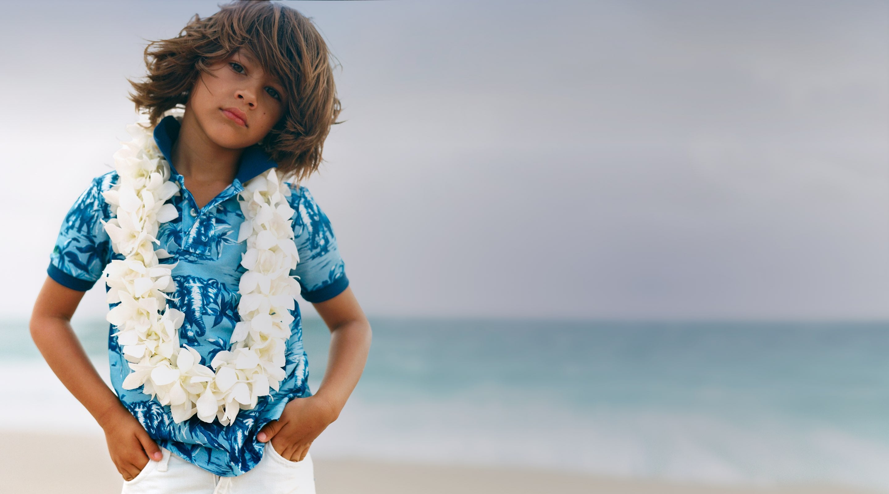 Boy in blue Hawaiian-print Polo shirt by ocean