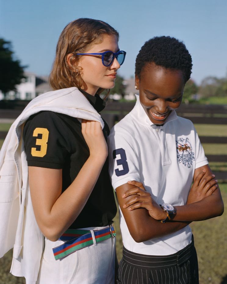 Women wear black & white Polo shirts with 3 at the sleeve.