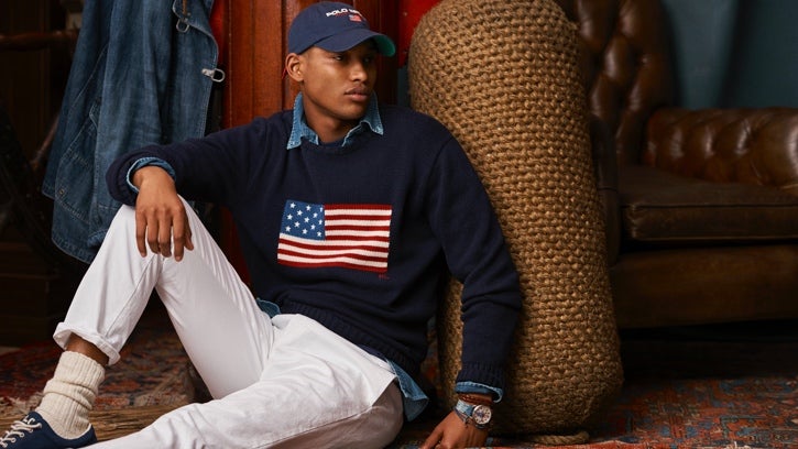 Man in navy American flag sweater & white jeans